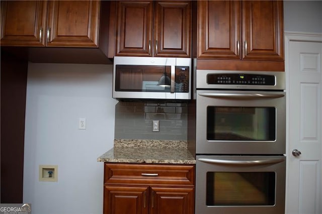 kitchen with light stone countertops and stainless steel appliances