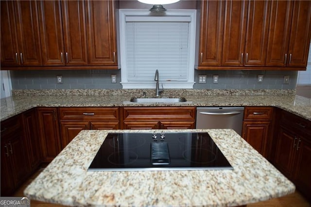 kitchen featuring black electric cooktop, dishwasher, sink, and light stone counters