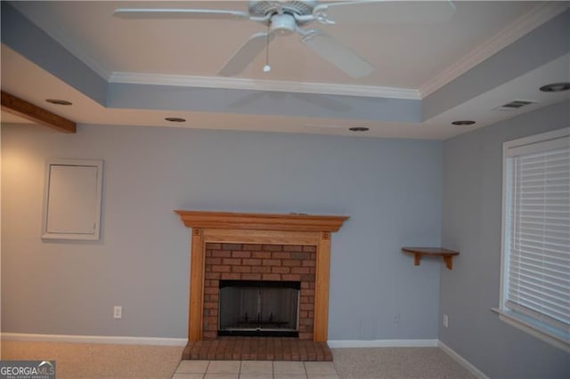 unfurnished living room featuring a raised ceiling, a brick fireplace, and crown molding