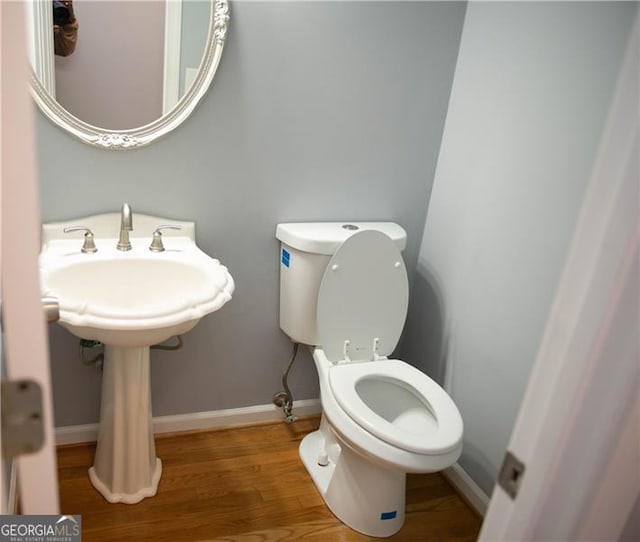 bathroom with hardwood / wood-style floors and toilet