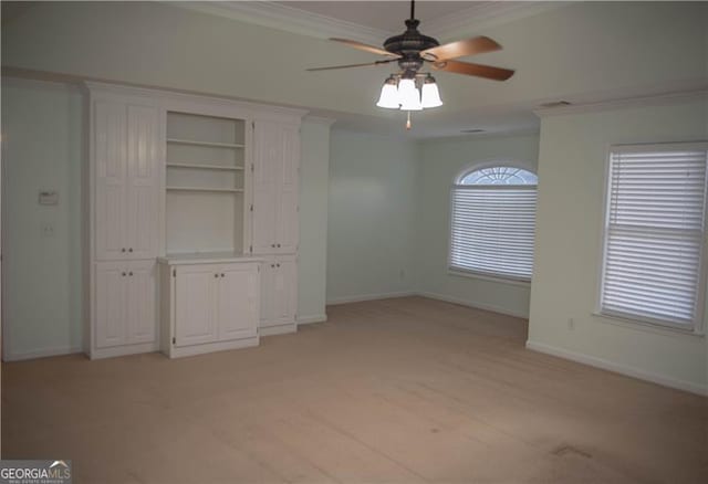 interior space featuring crown molding, ceiling fan, and light colored carpet