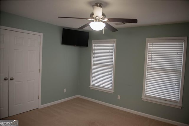 carpeted empty room with ceiling fan