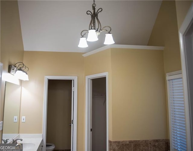 bathroom featuring toilet, vanity, and an inviting chandelier