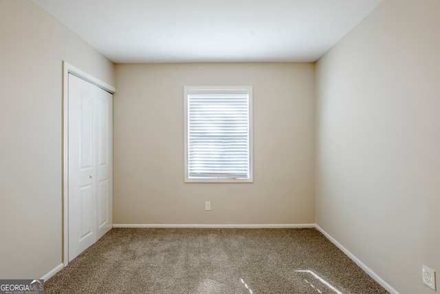 unfurnished bedroom with carpet flooring and a closet