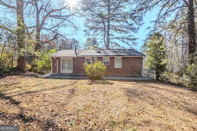 rear view of house featuring a patio area and a yard