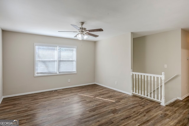 unfurnished room with ceiling fan and dark wood-type flooring