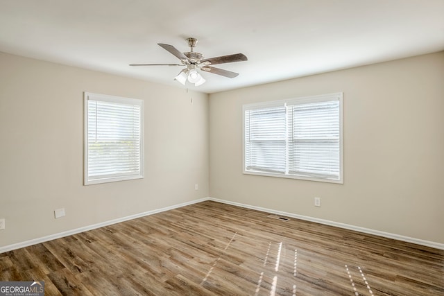 spare room with ceiling fan, plenty of natural light, and light hardwood / wood-style flooring