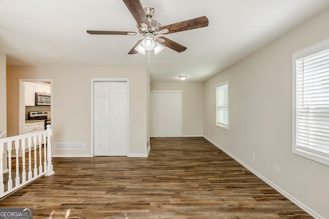 unfurnished bedroom featuring a nursery area, multiple windows, a closet, and ceiling fan