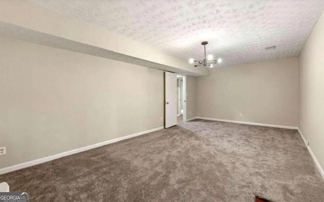 unfurnished room with carpet flooring, a textured ceiling, and a chandelier