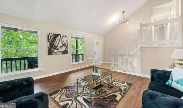 living room with hardwood / wood-style floors, plenty of natural light, and vaulted ceiling