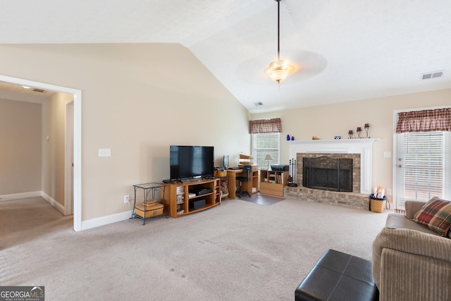 carpeted living room featuring ceiling fan, vaulted ceiling, and a brick fireplace