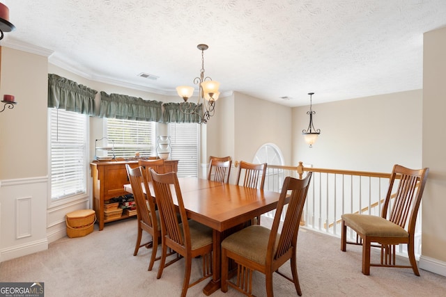 carpeted dining area featuring a notable chandelier and a textured ceiling