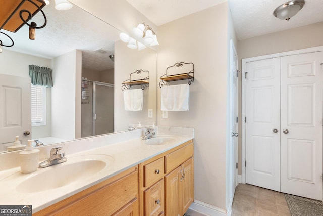 bathroom with vanity, a textured ceiling, and an enclosed shower