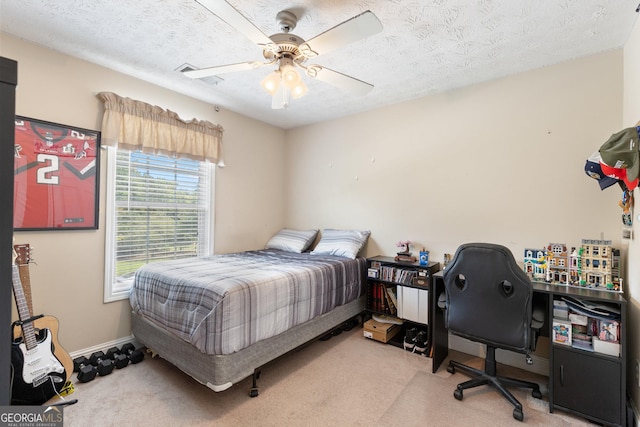 carpeted bedroom featuring ceiling fan and a textured ceiling