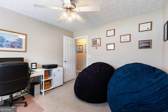 carpeted office featuring ceiling fan and a textured ceiling