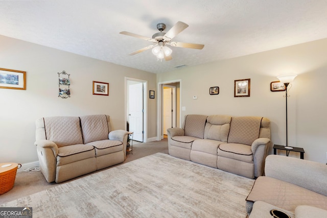 carpeted living room with ceiling fan