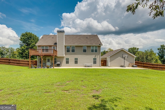 rear view of house featuring a lawn, a patio area, and a deck