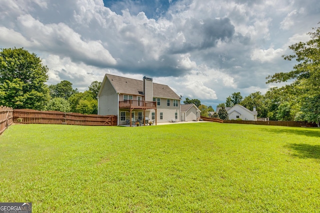 rear view of property with a lawn and a wooden deck