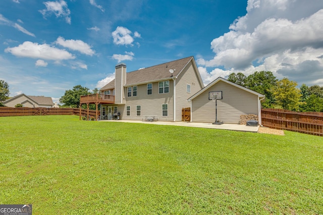 rear view of property featuring a lawn, a patio area, and a deck