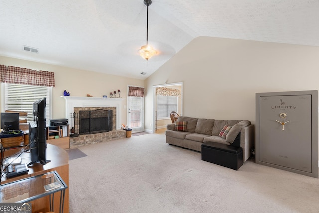 living room featuring a textured ceiling, a fireplace, light colored carpet, and lofted ceiling