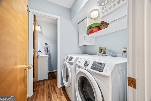 washroom with cabinets, dark wood-type flooring, and washer and dryer