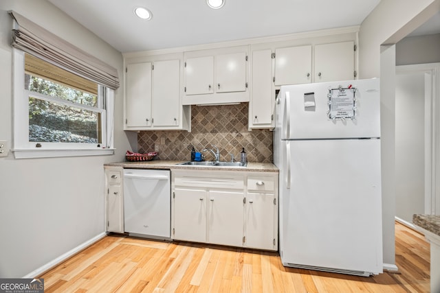 kitchen with backsplash, white appliances, sink, light hardwood / wood-style flooring, and white cabinetry