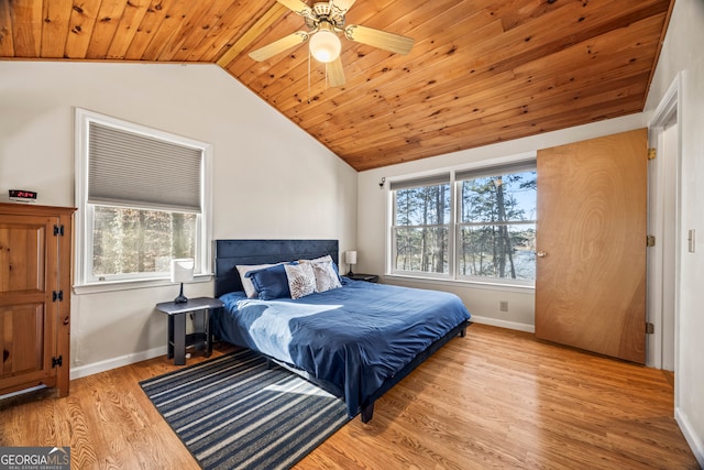 bedroom with light hardwood / wood-style floors, vaulted ceiling, ceiling fan, and wood ceiling