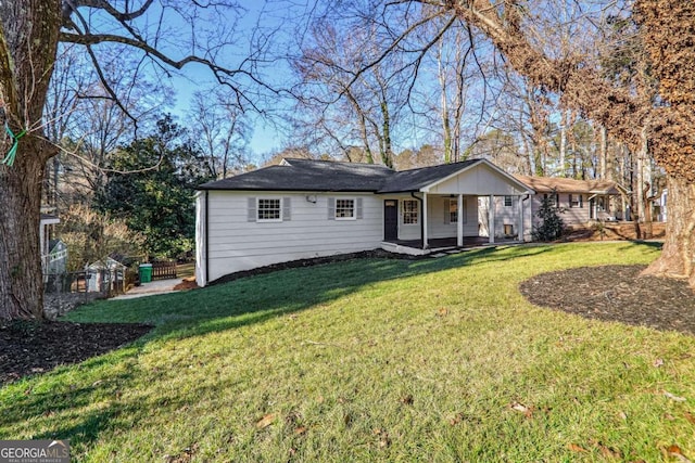 rear view of house featuring covered porch and a yard