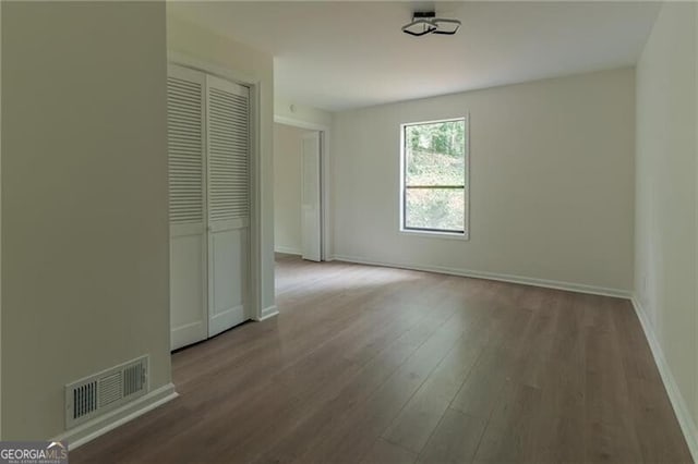 unfurnished bedroom with hardwood / wood-style flooring and a closet