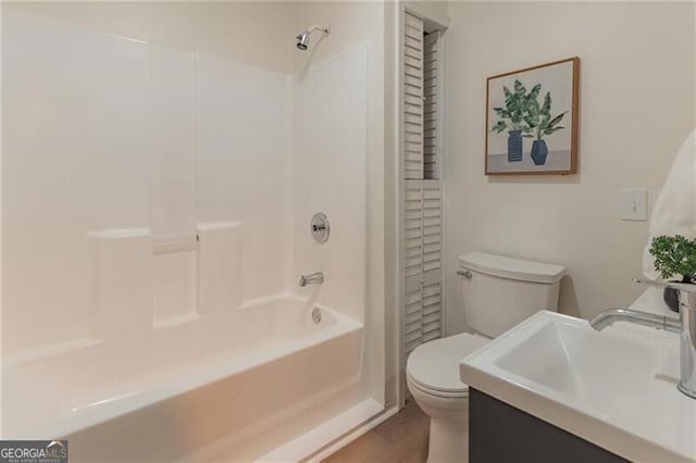 full bathroom with vanity, shower / bath combination, hardwood / wood-style flooring, and toilet