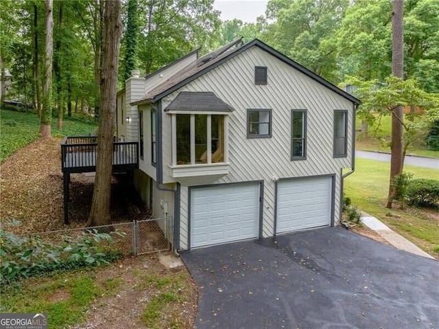 view of side of home featuring a garage and a wooden deck