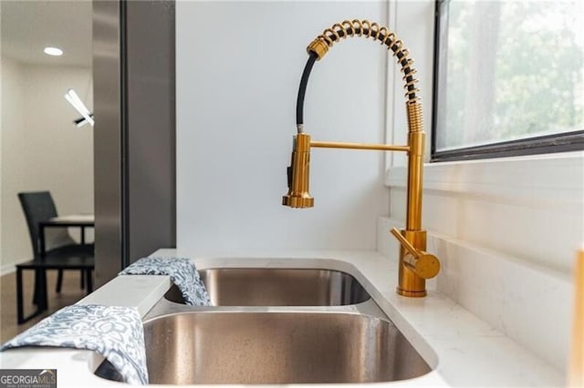 interior details featuring light stone countertops and sink