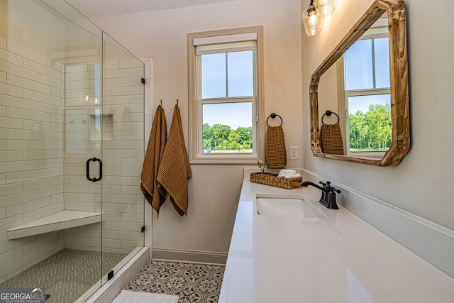 bathroom featuring tile patterned flooring, a shower with door, a healthy amount of sunlight, and sink