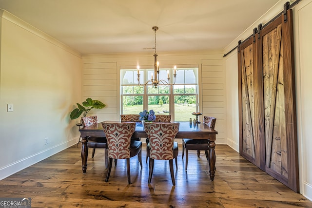 dining space featuring a notable chandelier, a barn door, crown molding, and dark hardwood / wood-style floors