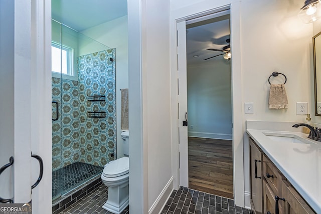 bathroom with vanity, toilet, an enclosed shower, and ceiling fan