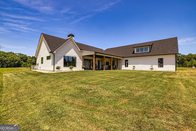 rear view of property featuring a lawn