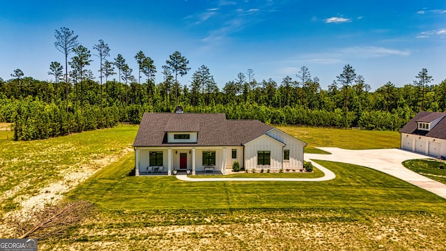 view of front of property featuring a porch, an outbuilding, a front yard, and a garage