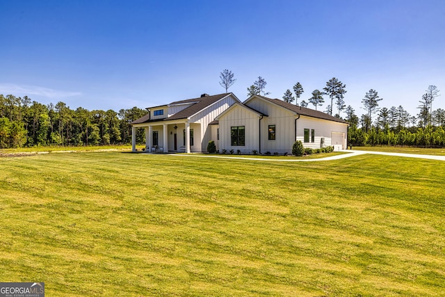 modern farmhouse style home with a porch, a front yard, and a garage