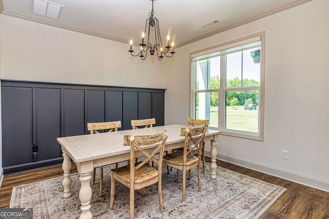 dining space with crown molding, a chandelier, and dark hardwood / wood-style floors