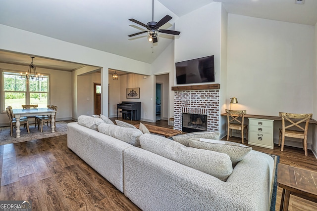 living room featuring a fireplace, ceiling fan with notable chandelier, dark hardwood / wood-style floors, and high vaulted ceiling