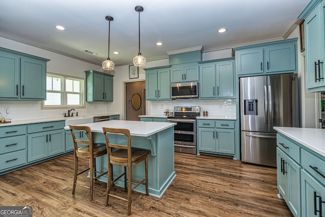 kitchen featuring pendant lighting, a center island, stainless steel appliances, and tasteful backsplash