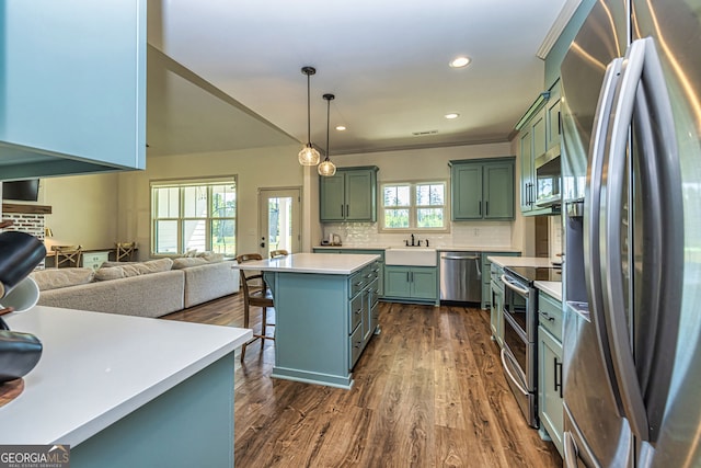 kitchen with a center island, stainless steel appliances, plenty of natural light, and hanging light fixtures