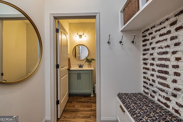 mudroom featuring sink, brick wall, and dark hardwood / wood-style floors