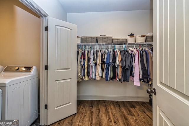 spacious closet featuring washer / dryer and dark wood-type flooring