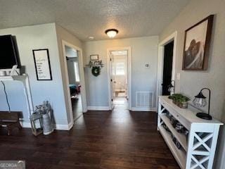 corridor with dark wood-type flooring and a textured ceiling