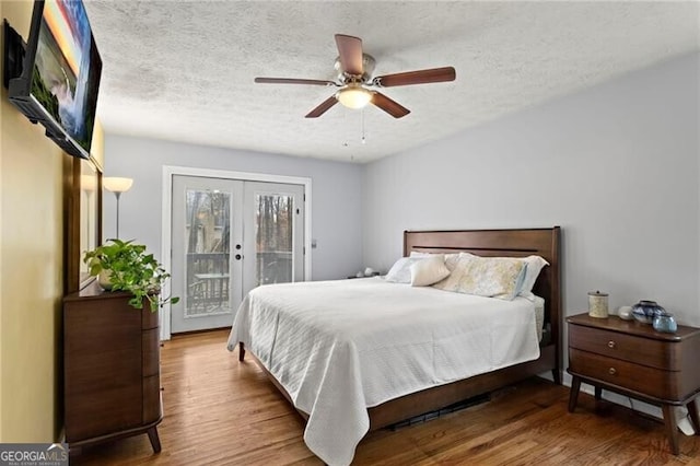 bedroom with french doors, hardwood / wood-style flooring, ceiling fan, access to exterior, and a textured ceiling