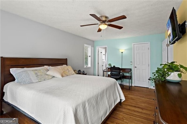 bedroom featuring a textured ceiling, dark hardwood / wood-style flooring, and ceiling fan