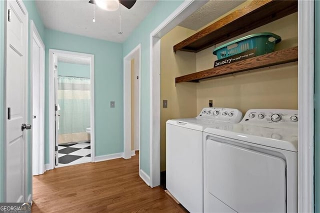 washroom with washer and clothes dryer, ceiling fan, and dark hardwood / wood-style flooring