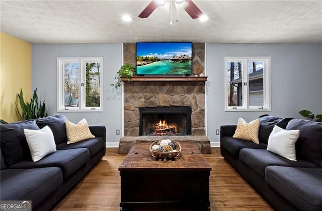 living room featuring hardwood / wood-style floors, a fireplace, a healthy amount of sunlight, and a textured ceiling