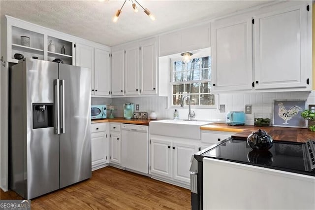 kitchen with white cabinets, hardwood / wood-style floors, white appliances, and a chandelier